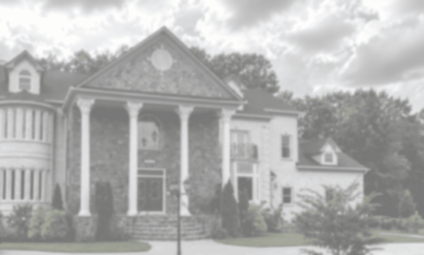 A stone-front home with a columned portico
